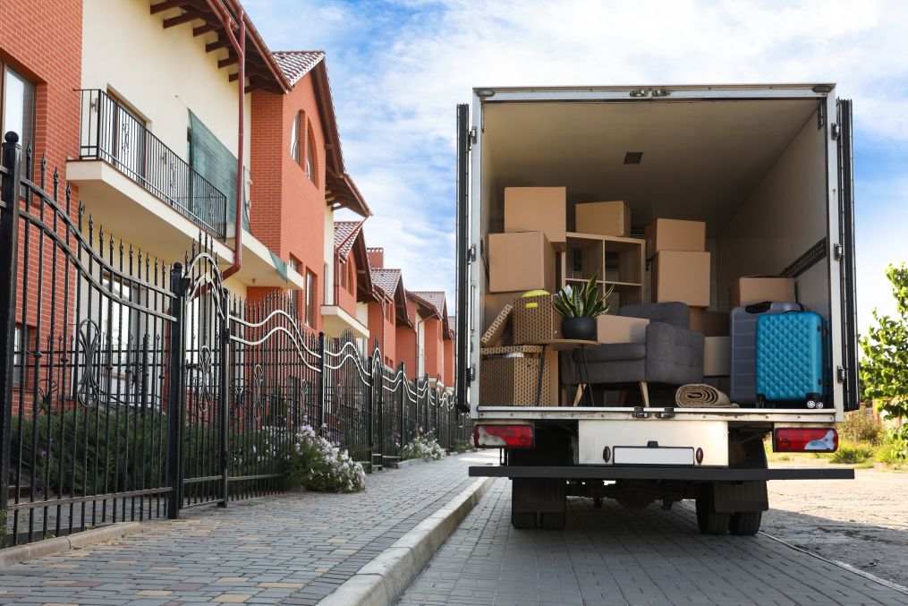 Van full of moving boxes and furniture near house