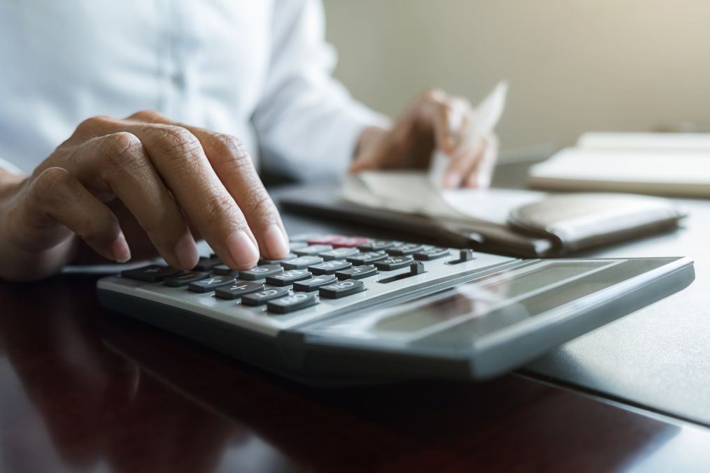 Woman with bills and calculator. Woman using calculator to calculate bills at the table in office. Calculation of costs.