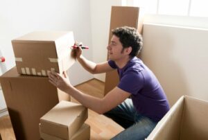 Young man packing boxes