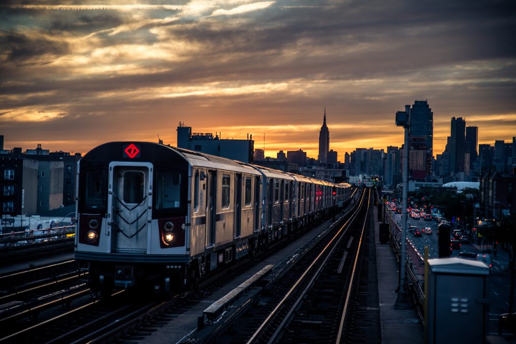 Subway train in New York at sunset and Manhattan cityscape view