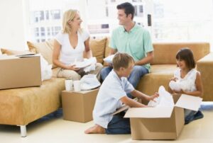 Family unpacking boxes in new home smiling