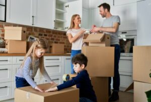 Family packing cardboard boxes for moving house