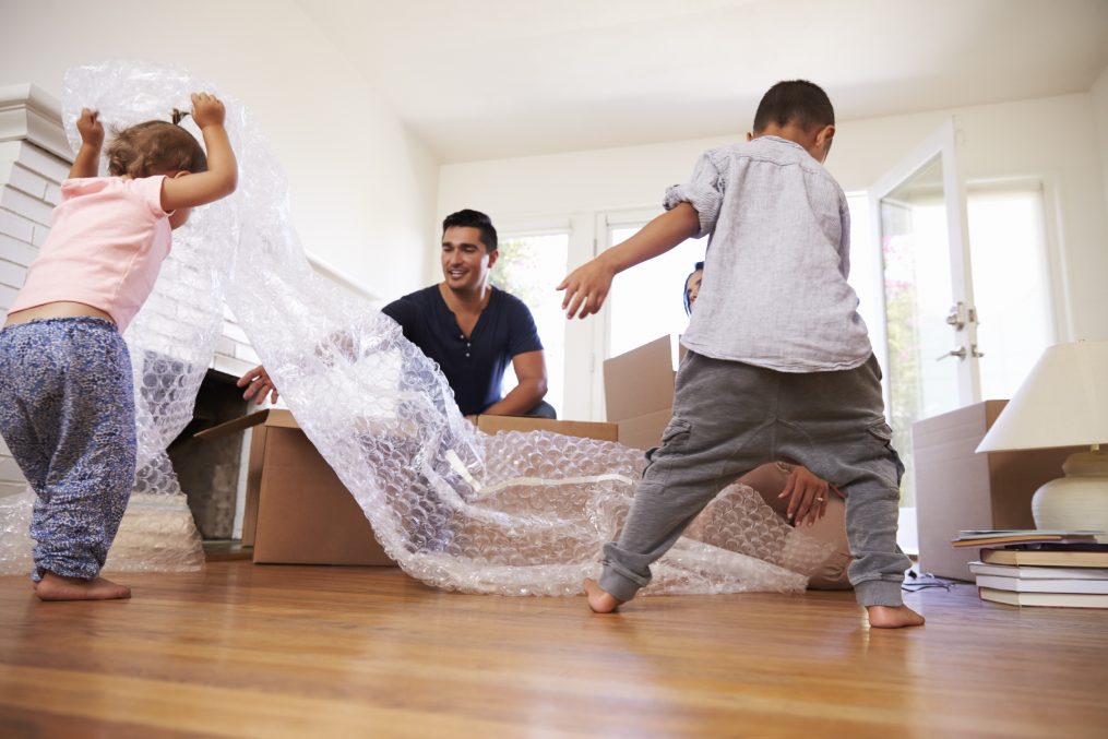 Family Unpacking Boxes In New Home On Moving Day