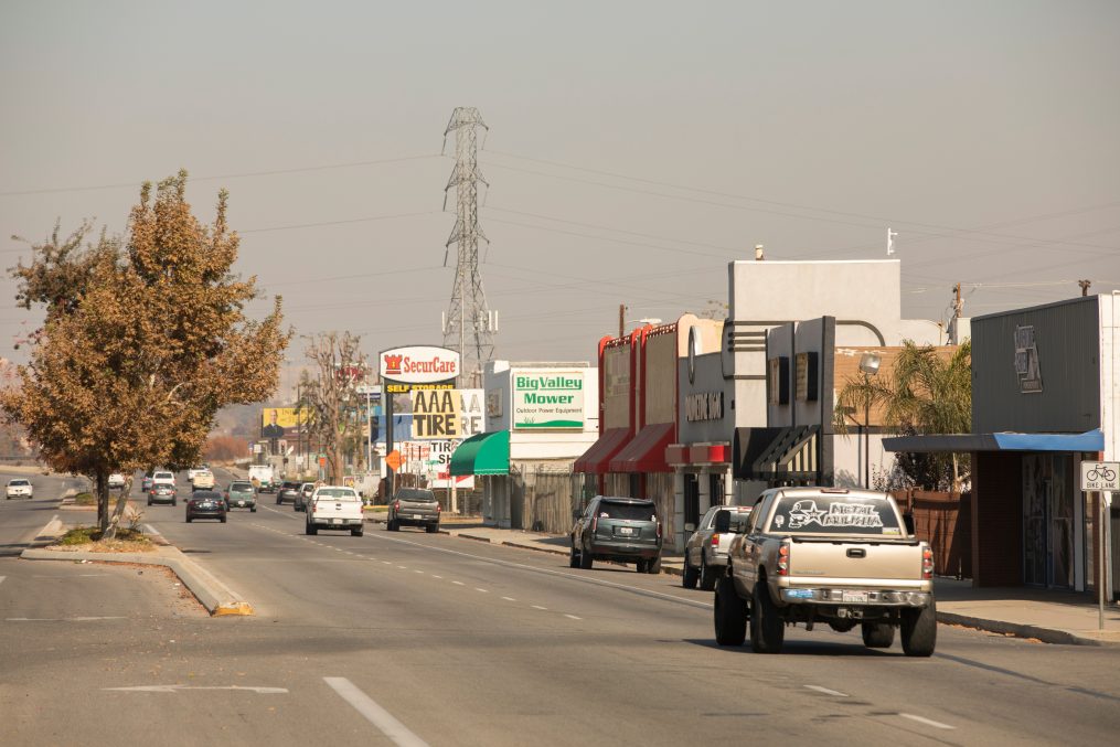 Bakersfield, California, USA - December 01, 2020: Automobiles pass down Chester Avenue under a polluted sky.