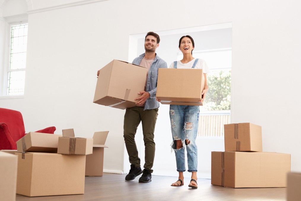 Couple Carrying Boxes Into New Home On Moving Day