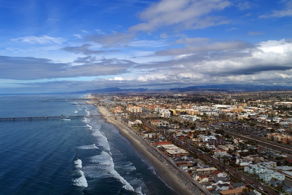 Beautiful dramatic drone panoramic aerial birds eye view Oceanside, California, Oceanside Pier Oceanside harbor and downtown plus miles of beach and dynamic cloudscape