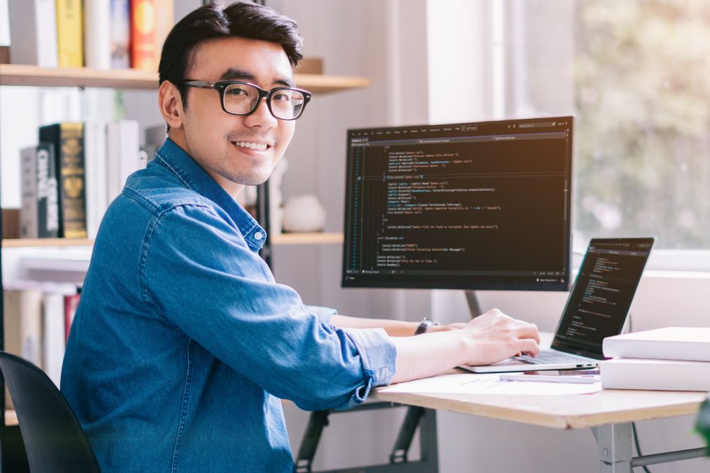 Young Asian programmer working at office