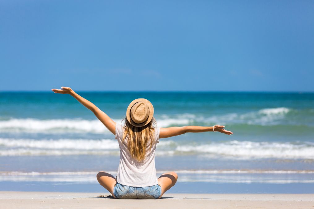 Happy woman traveler relaxing on a perfect beach