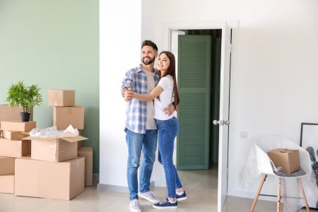 Young couple with belongings in their new house