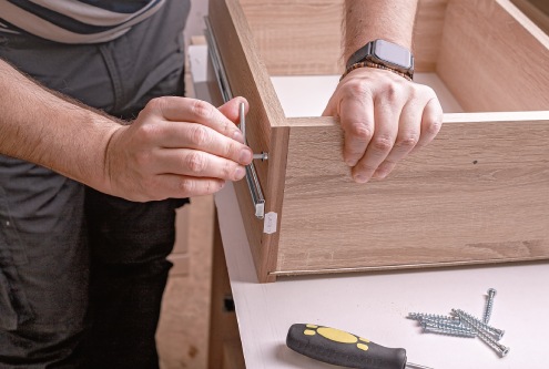 Mans hands assembling furniture.