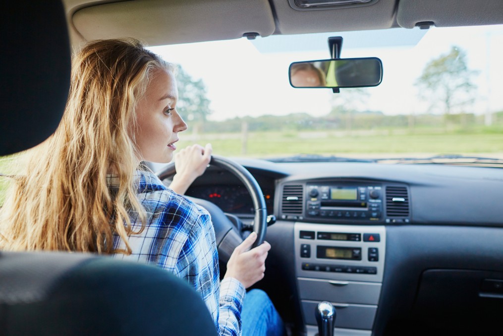 Beautiful young confident woman driving a car