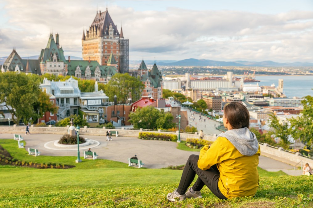 Canada travel Quebec city tourist enjoying view of Chateau Frontenac castle and St. Lawrence river in background. 