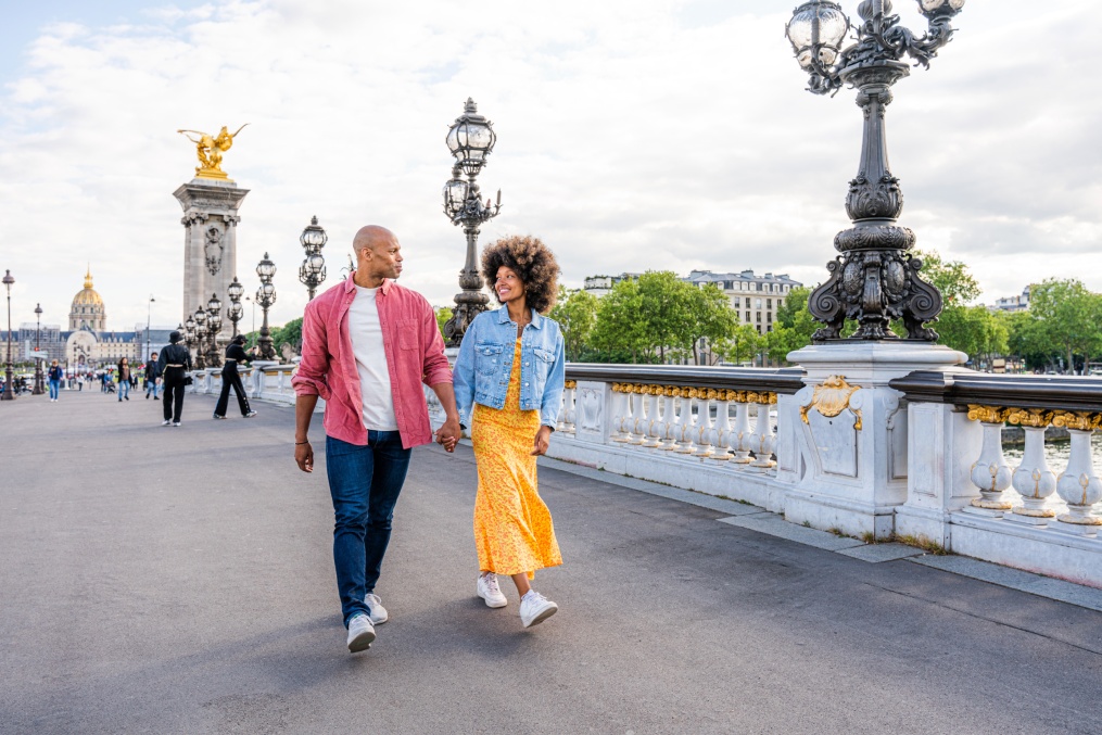 Black cheerful happy couple in love visiting Paris city centre and Eiffel Tower - African american tourists travelling in Europe and dating outdoors