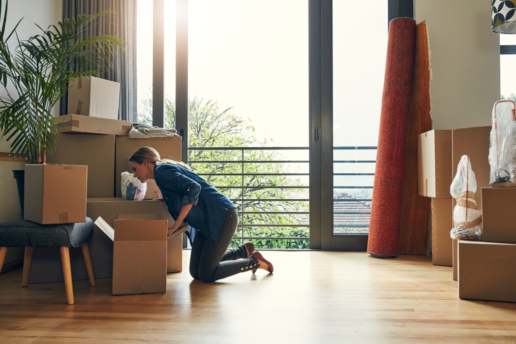 New home, moving and woman packing box for property sale, mortgage and house investment. Real estate, unboxing and person with cardboard for relocation, packaging or storage for delivery to apartment