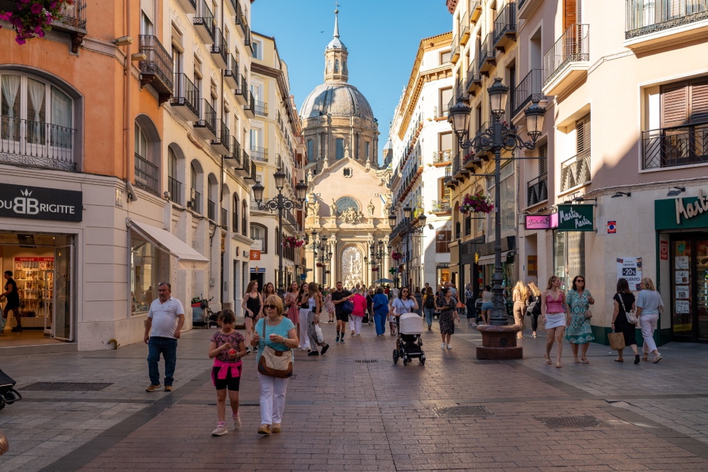 ZARAGOZA, Spain - June 24 2024: City center of Zaragoza, street Alfonso I. People passing. In background is Cathedral of Zaragoza. Famous travel destination in Aragon, Spain. Pedestrian street.