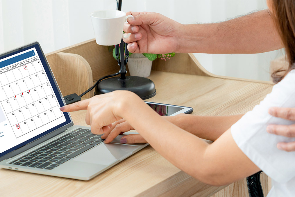 2 persons are seeing computer with a cup of coffee.