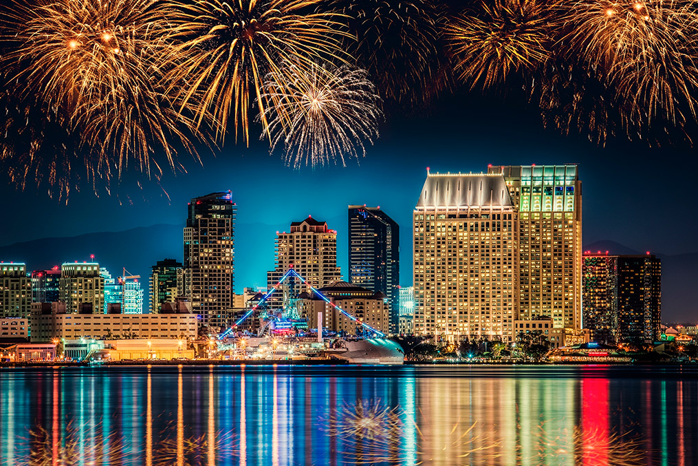 A vibrant firework display illuminates the San Diego skyline during a summer event celebration.