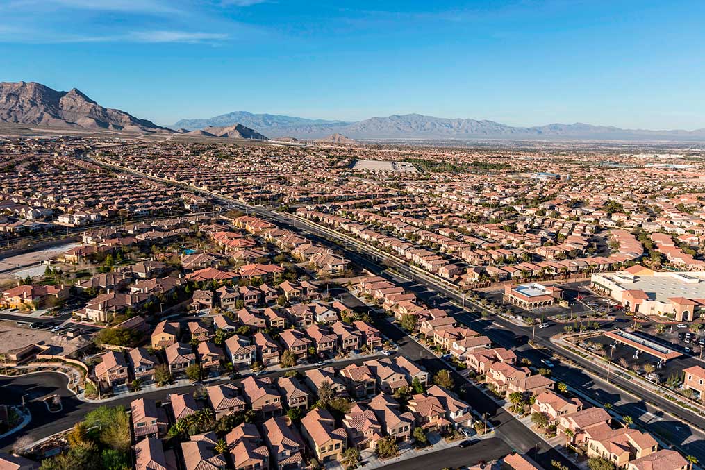 Overhead view of a city with residential areas and mountains, relevant to the Desert Living Guide for relocating to Las Vegas.