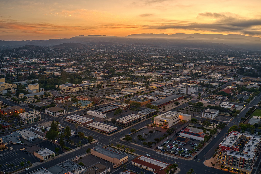 Sunset over Escondido, CA, captured from above, highlighting the city's layout and warm hues of the evening sky.