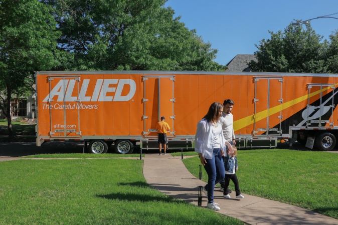 family with moving truck behnhind. California In-State & Intrastate Movers by Atlas