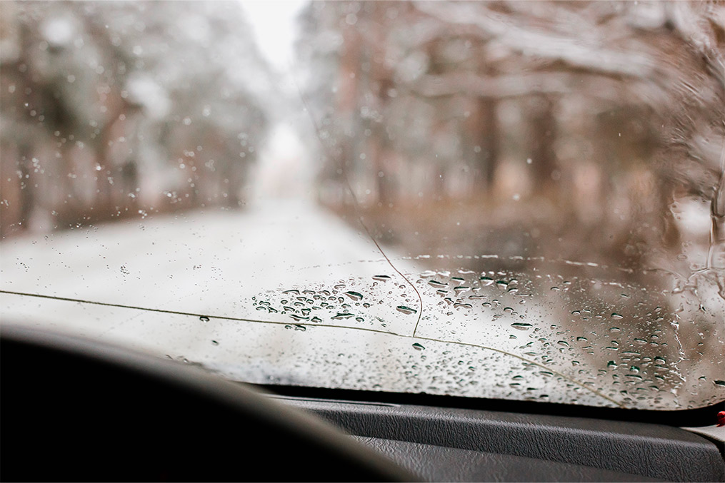 A snowy car windshield, representing the winter environment discussed in the guide to moving success.