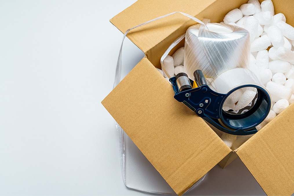 A box featuring a pair of scissors and gloves, highlighting items for effective winter moving preparation.