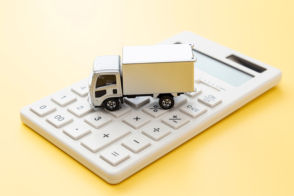  A white truck positioned atop a calculator, representing calculations for "The Complete Guide to Winter Moving Success."