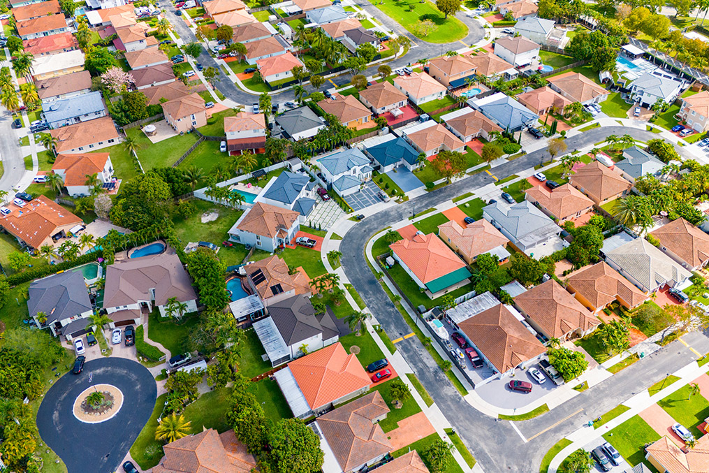 Aerial perspective of a Miami neighborhood, highlighting residential areas and lush landscapes in a coastal city comparison.