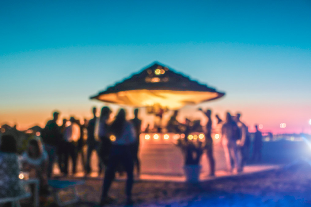 Unclear image of individuals on a beach, representing the coastal environments of San Diego and Miami.