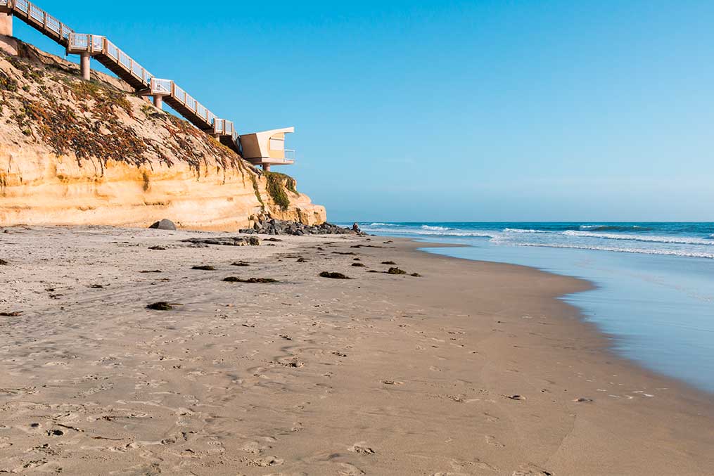 A picturesque beach scene featuring a house on the sand, highlighting the beauty of Solana Beach living.