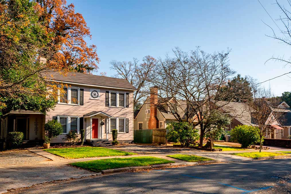 A house with a red door and a tree in the front yard, representing a transition from San Diego to Charlotte, NC.