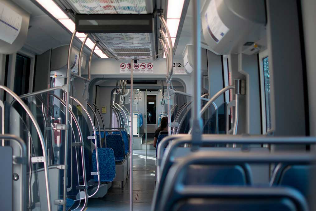 Inside a train featuring rows of seats and glimpses of the landscape outside.