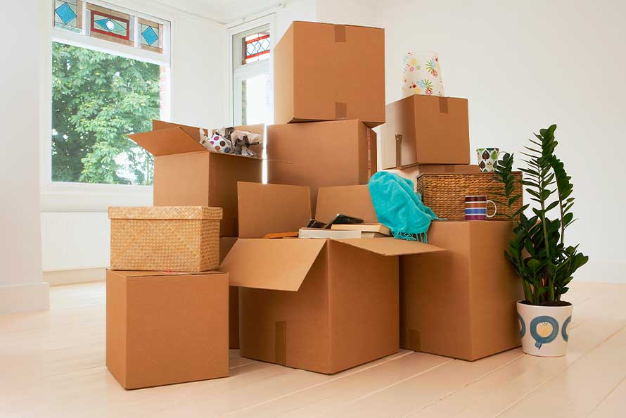 A collection of packed moving boxes in a vacant room, signifying a move from San Diego to London.
