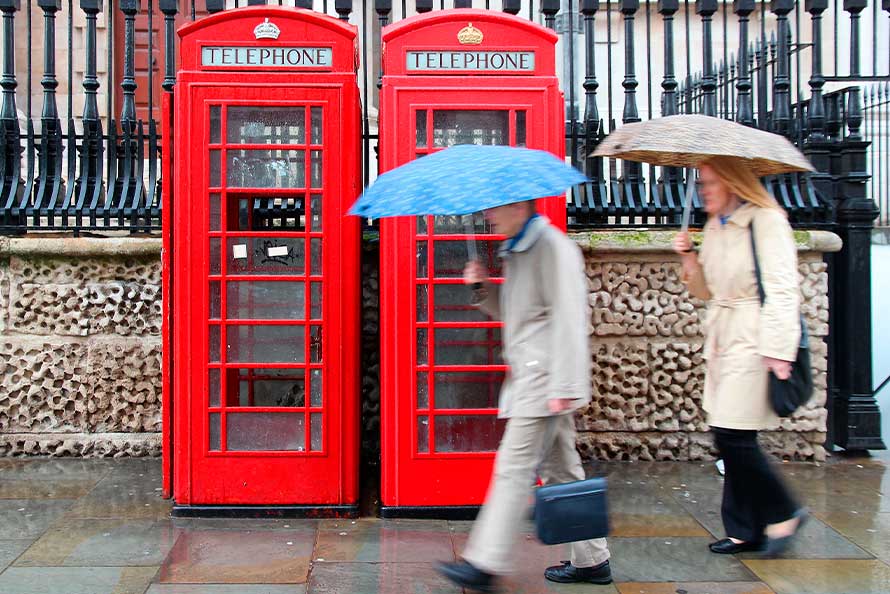 Two individuals stroll through the rain, embracing their relocation from San Diego to London.