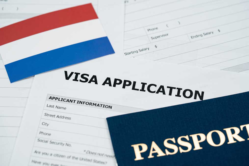 View of Netherlands visa application form with passport and national flag.