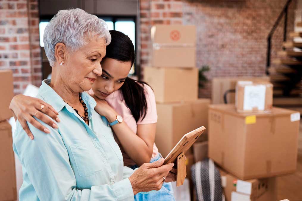Every home has a history. Shot of a senior woman looking at a photograph with her daughter while packing boxes on moving day.