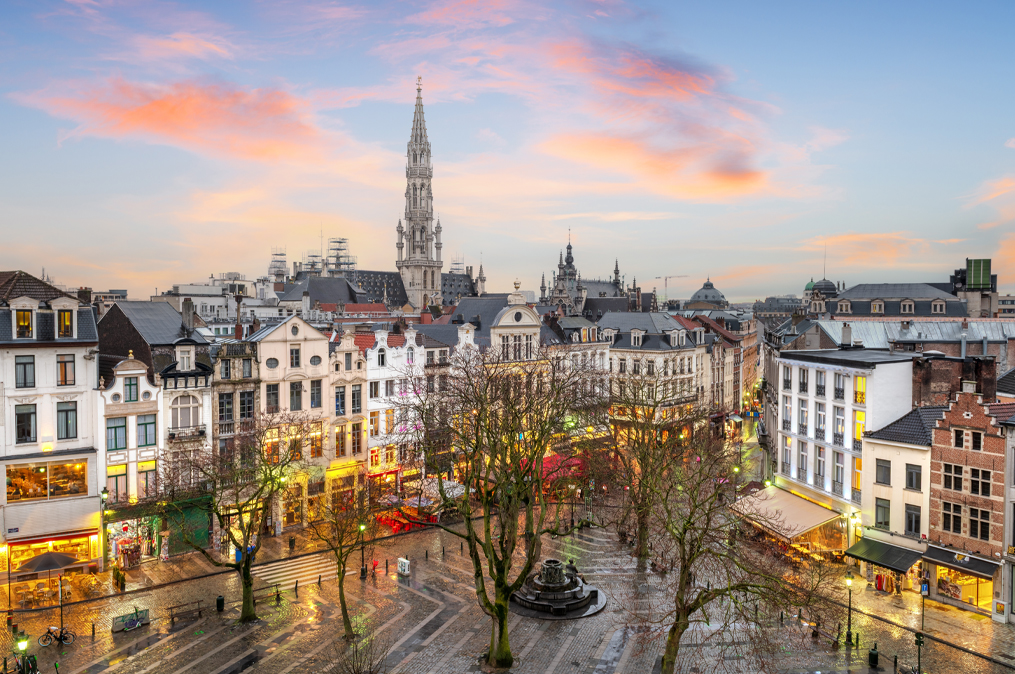 Brussels, Belgium plaza and skyline with the Town Hall tower at dusk.