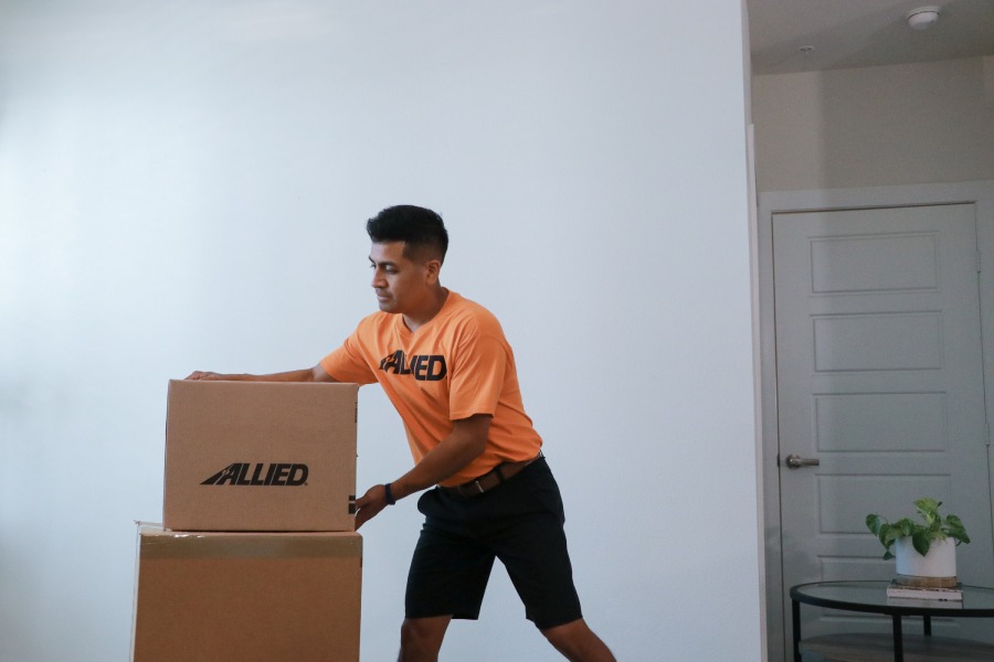 Office movers in San Diego rolling moving crates through a modern office