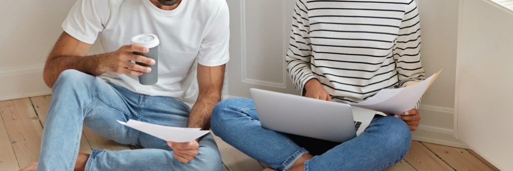 Couple crunching number sitting on the floor